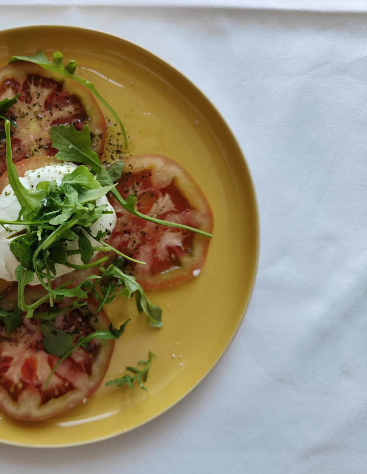 Sa Baronia Restaurant Detail of a salad of tomato, cheese and rocket.